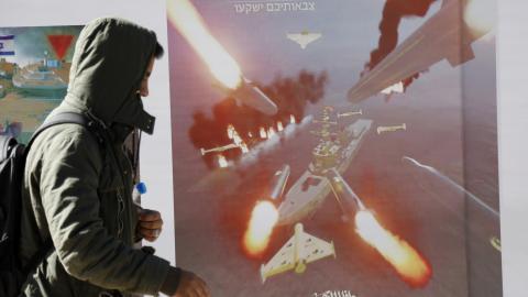 A man walks next to a billboard bearing the image missiles targeting ships on January 17, 2024, in Sanaa, Yemen. (Photo by Mohammed Hamoud/Getty Images)