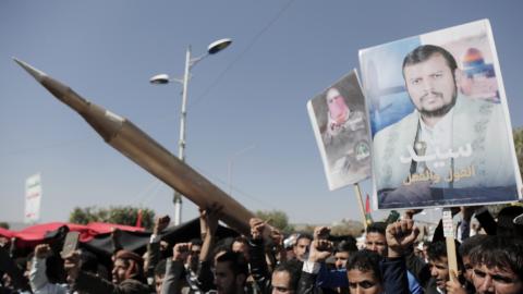 Yemenis lift a Palestinian flag and placards depicting Houthi group leader Abdul-Malik Badreddin al-Houthi and Abu Obaida, the spokesperson of Hamas' armed wing, on January 24, 2024, in Sana'a, Yemen. (Photo by Mohammed Hamoud/Getty Images)