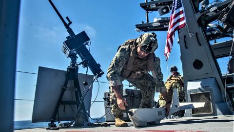 A crewman does preflight checks on an unmanned aerial vehicle (UAV) for launch aboard a MKVI patrol boat on October 16, 2019, in the Pacific Ocean. (US Navy photo by Chief Boatswain’s Mate Nelson Doromal Jr.)