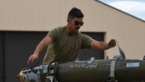 An airman unstraps an inert Joint Direct Attack Munition (JDAM) during the Lone Star Challenge at Dyess Air Force Base, Texas, on July 13, 2023. (US Air Force photo)