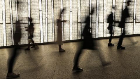 People are seen silhouetted against a storefront display in Hong Kong on September 27, 2020. (May James/AFP via Getty Images)