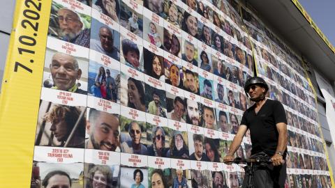  A man passes by a building covered with photos of hostages who have been released or are still being held in the Gaza Strip, on March 26, 2024 in Tel Aviv, Israel. Foreign mediators in the ongoing Israel-Hamas ceasefire negotiations have expressed cautious optimism about the talks, but a breakthrough remains elusive. Israel has vowed that it will still press on with a ground invasion of Rafah, the Gaza Strip's southernmost city, even if a temporary ceasefire is agreed to.(Photo by Amir Levy/Getty Images)