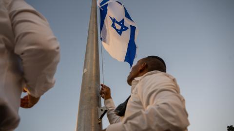 Workers raise the Israeli flag at the Western Wall before the "In Memoriam of 1,400 Souls: Special Candle-Lighting Ceremony" begins marking 30 days since the Oct 7th Hamas attack, at the Western Wall on November 6, 2023 in Jerusalem. Families of victims killed, as well as those hostages and others effected participated in the ceremony, which included the lighting of over 1400 yahrzeit Memorial candles. (Photo by Alexi J. Rosenfeld/Getty Images)