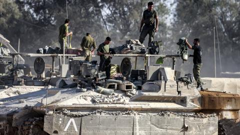 Israeli army soldiers check their gear atop an infantry fighting vehicle (IFV) stationed at a position along the border with the Gaza Strip and southern Israel on July 14, 2024. (Photo by Menahem Kahana/AFP via Getty Images)