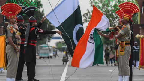 Indian Border Security Force personnel and Pakistani Rangers lower their respective flags during the daily beating retreat ceremony at the India-Pakistan Wagah Post on August 15, 2021. (Narinder Nanu via Getty Images)