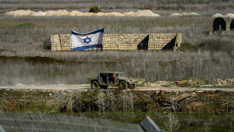 An Israel Defense Forces jeep drives past an Israeli flag on January 9, 2025, in Metula, Israel. (Getty Images)