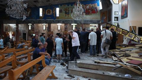 People survey the scene following a blast in the Mar Elias Church on June 22, 2025, in Damascus, Syria. A suspected suicide bombing killed at least 20 people and injured 52 others who were attending a service at the church. (Ali Haj Suleiman via Getty Images)