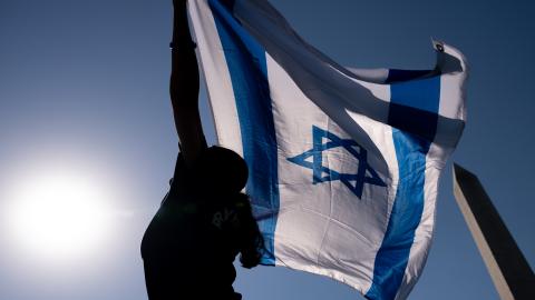 The Washington Monument is visible as a woman holds an Israeli flag at the October 7th Memorial Rally in Washington, DC, on October 7, 2024. (Getty Images) Share to Twitter