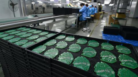 A woman works on a printed circuit board at an electronics factory in Anhui, China, on Friday, October 31, 2025. (Getty Images)