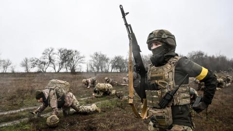 Recruits crawl a designated distance with combat gear under the supervision of instructors during the zero day of basic combined arms training with the 65th Separate Mechanized Brigade at an improvised training ground in Ukraine, on December 12, 2025 (Photo by Dmytro Smolienko/Ukrinform). NO USE RUSSIA. NO USE BELARUS. (Photo by Ukrinform/NurPhoto via Getty Images)