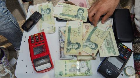Stacks of Iranian rials and US dollars sit counted on a table in Tehran, Iran, on August 6, 2025. (Getty Images) Share to Twitter
