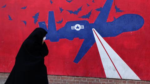 A woman walks past a mural depicting a US drone painted on the outer walls of the former US embassy in Tehran, on February 1, 2026. (Getty Images)