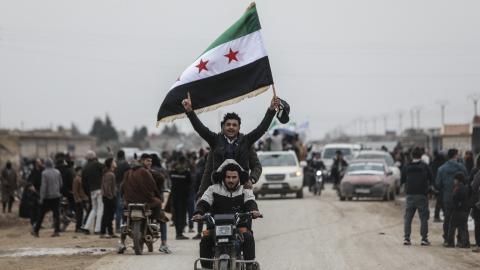 Men riding a motorbike wave a Syrian flag as Syrian government forces enter the Kurdish-majority city of Qamishli on February 3, 2026. (Getty Images)