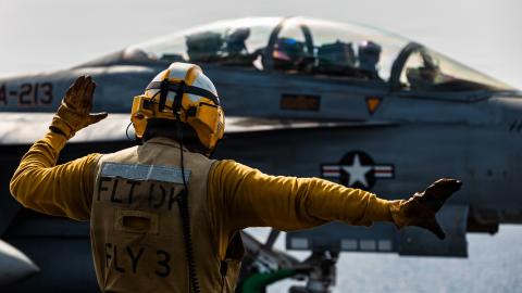 A U.S. Sailor signals to an F/A-18F Super Hornet aircraft, attached to Strike Fighter Squadron 213, as it approaches a catapult on the flight deck of the USS Gerald R. Ford (CVN 78), while underway, March 17, 2026. (U.S. Navy photo)