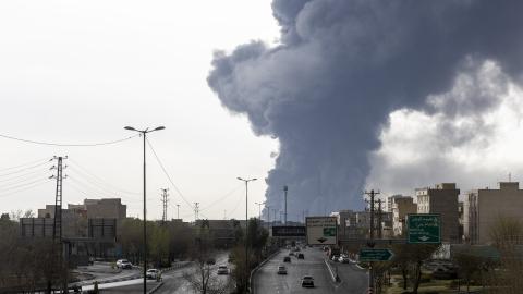Cars drive down a highway as smoke billows after overnight airstrikes on oil depots on March 8, 2026, in Tehran, Iran. (Getty Images)