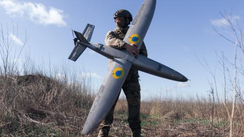 : A portrait of a soldier from the "Taifun" unmanned aerial vehicle unit holding a new model 'Marsianin' attack drone on April 7, 2026 in Kharkiv region, Ukraine. After years of developing systems and know-how to fend off Russia's drone attacks, Ukraine is now offering its hard-won expertise and counter-drone technology to other countries. In recent weeks, Ukrainian President Volodymyr Zelensky has been visiting Gulf states who are confronting a wave of relatively cheap kamikaze drones launched by Iran as i