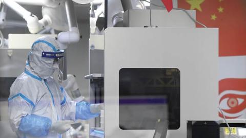 Laboratory technicians wearing personal protective equipment (PPE) working on samples to be tested for the Covid-19 coronavirus. (Getty Images)