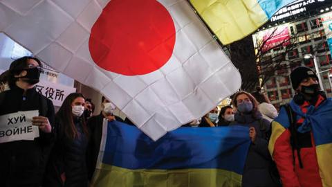 Protesters hold signs and chant slogans during a protest in front of the Shibuya Station on February 24, 2022, in Tokyo, Japan. (Getty Images)