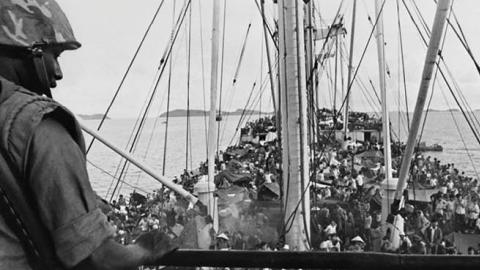 An American soldier watches over South Vietnamese refugees on a U.S. Navy boat off the coast of Vietnam, May 5, 1975. (AGENCE FRANCE-PRESSE/GETTY IMAGES)