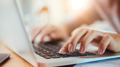 A woman types on her laptop keyboard (Getty)