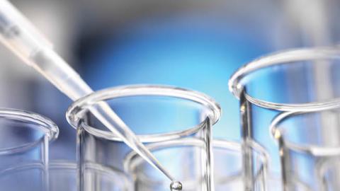 A scientist pipettes a sample into a test tube while conducting medical research. (Getty Images/Westend61)