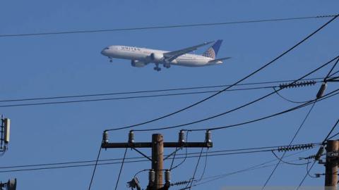 A United Airlines plane flies by a cellular tower as it prepares to land at San Francisco International Airport on January 19, 2022 in San Francisco, California. (Photo by Justin Sullivan/Getty Images)