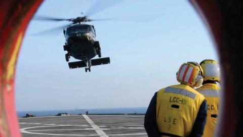 The amphibious command ship USS Blue Ridge flight deck crew prepare to land an SH-60B Sea Hawk assigned to Light Helicopter Antisubmarine squadron 51 on the flight deck. (U.S. Navy)