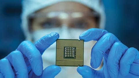 Engineer analyzes a computer chip in a lab. (D-Keine/Getty Images)