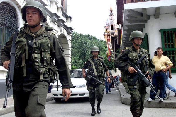 Military police patrol a street in Cartagena, Colombia, on August 29, 2000, as the city as prepares for the visit of President Bill Clinton (Photo by Marcelo Salinas/AFP via Getty Images)