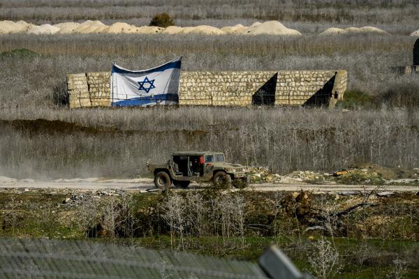 An Israel Defense Forces jeep drives past an Israeli flag on January 9, 2025, in Metula, Israel. (Getty Images)