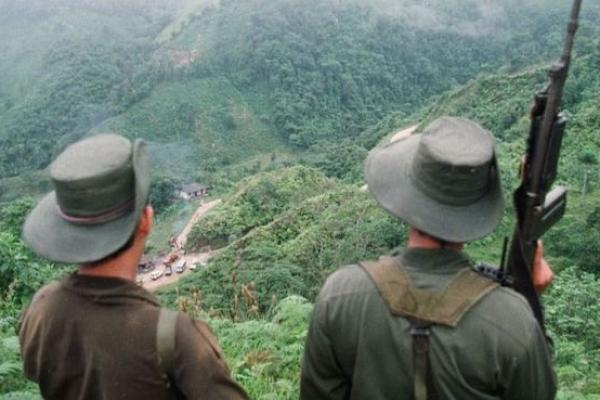 Two armed soldiers belonging to the Revolutionary Armed Forces of Colombia (FARC) monitor the Berlin pass, near Florencia, in the southern Caqueta province of Colombia, March 7, 1998. (PEDRO UGARTE/AFP/Getty Images)