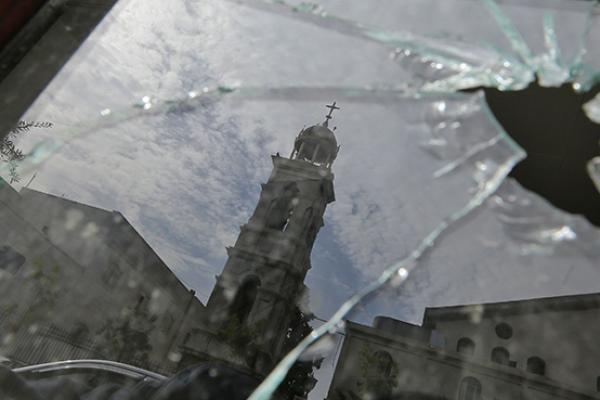 Greek Orthodox Church in Damascus reflected in window broken by rebel mortar bombardment, February 8, 2018