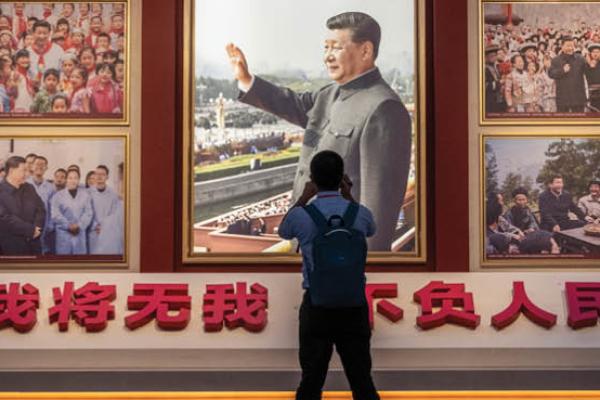 A man takes a photo of a wall showing images of Communist Party Chairman and President Xi Jinping as part of a display at the newly built Museum of the Communist Party of China on June 25, 2021, in Beijing, China. (Getty Images)