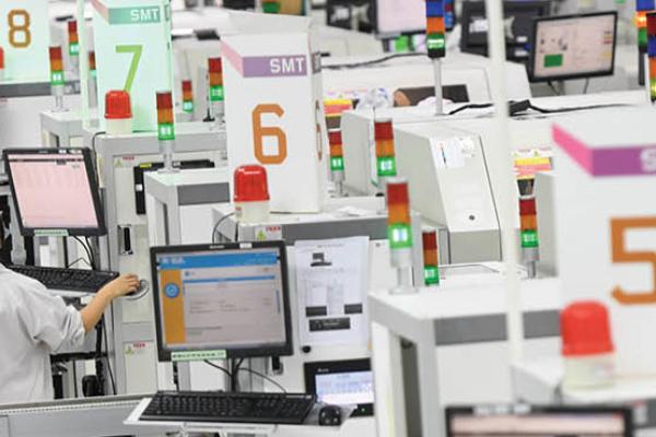 People work on the equipment for surface mount technology (SMT) at an assembly plant in Wuhan, China, on Friday, August 20, 2021. (Getty Images)