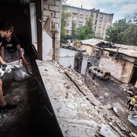 Workers collect glass and debris after a Russian Shahed drone strikes the city of Kharkiv, Ukraine, on July 30, 2025. (Francisco Richart Barbeira via Getty Images)