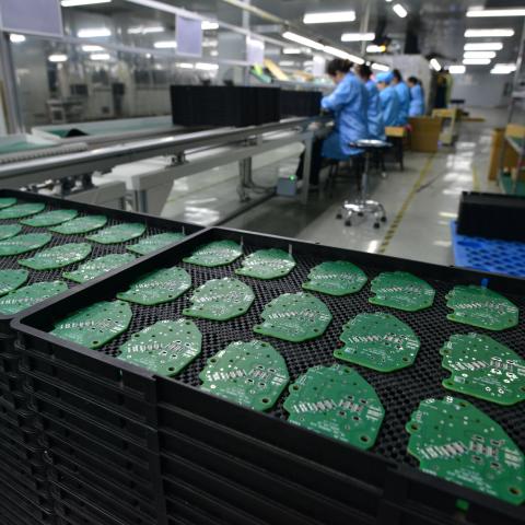 A woman works on a printed circuit board at an electronics factory in Anhui, China, on Friday, October 31, 2025. (Getty Images)